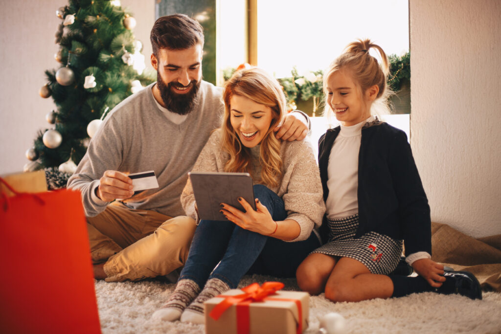Compras de Natal em família, criança usando o tablet, como acumular pontos no cartão de crédito.