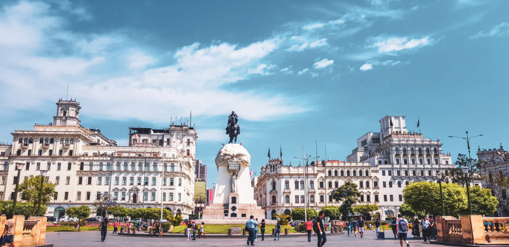 Na imagem vemos o centro de Lima, capital do Peru. Há um monumento histórico no centro da praça e algumas construções antigas. Lima é um dos melhores lugares para conhecer no Peru