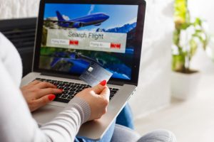 Imagem mostra pessoa comprando passagem aérea para juntar pontos em compras online
